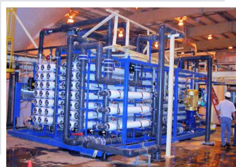 Reverse osmosis water treatment skid with membrane housings in a manufacturing facility